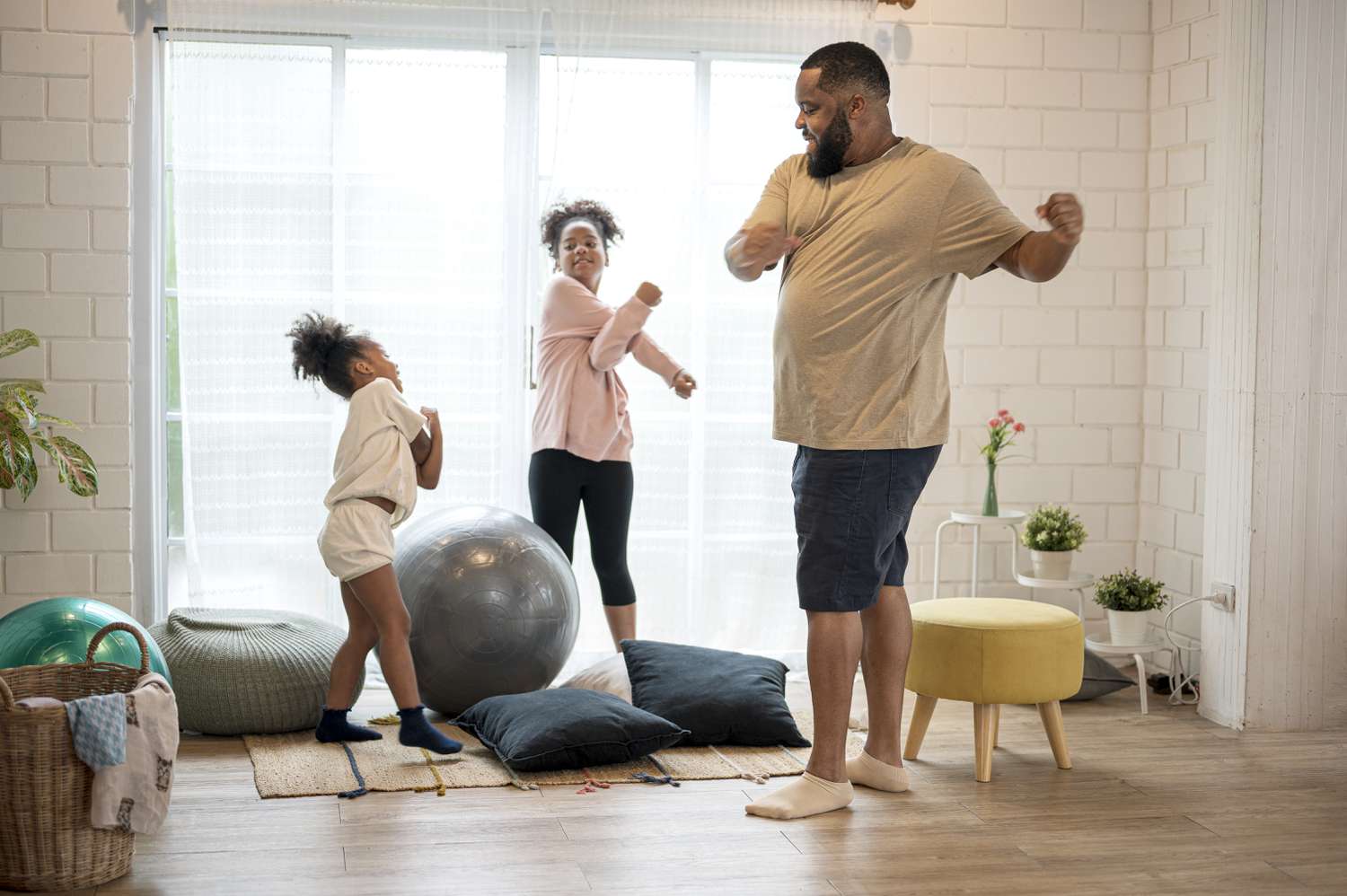 African American father and his two daughter morning exercise at home.