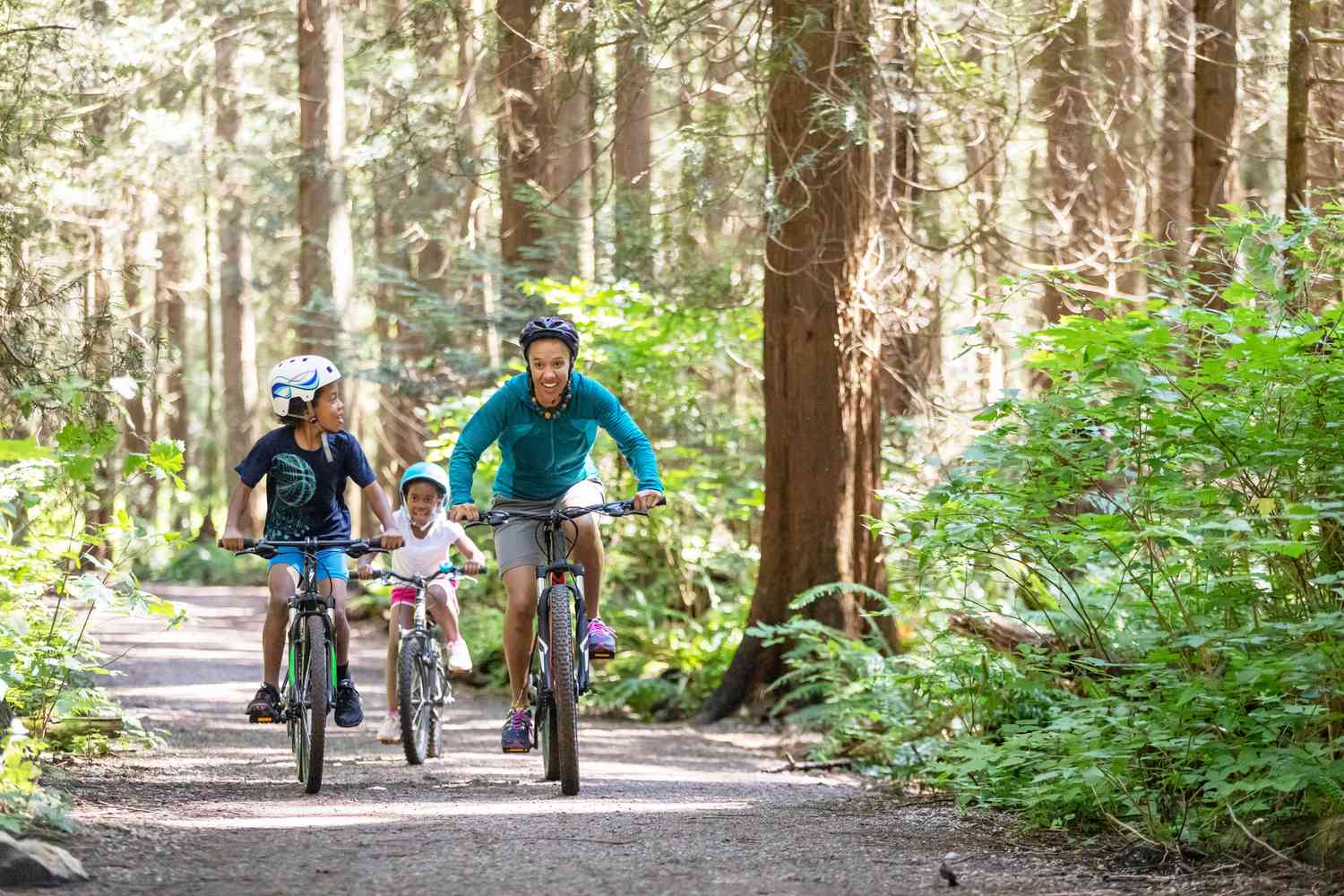Family riding bikes outside in the woods