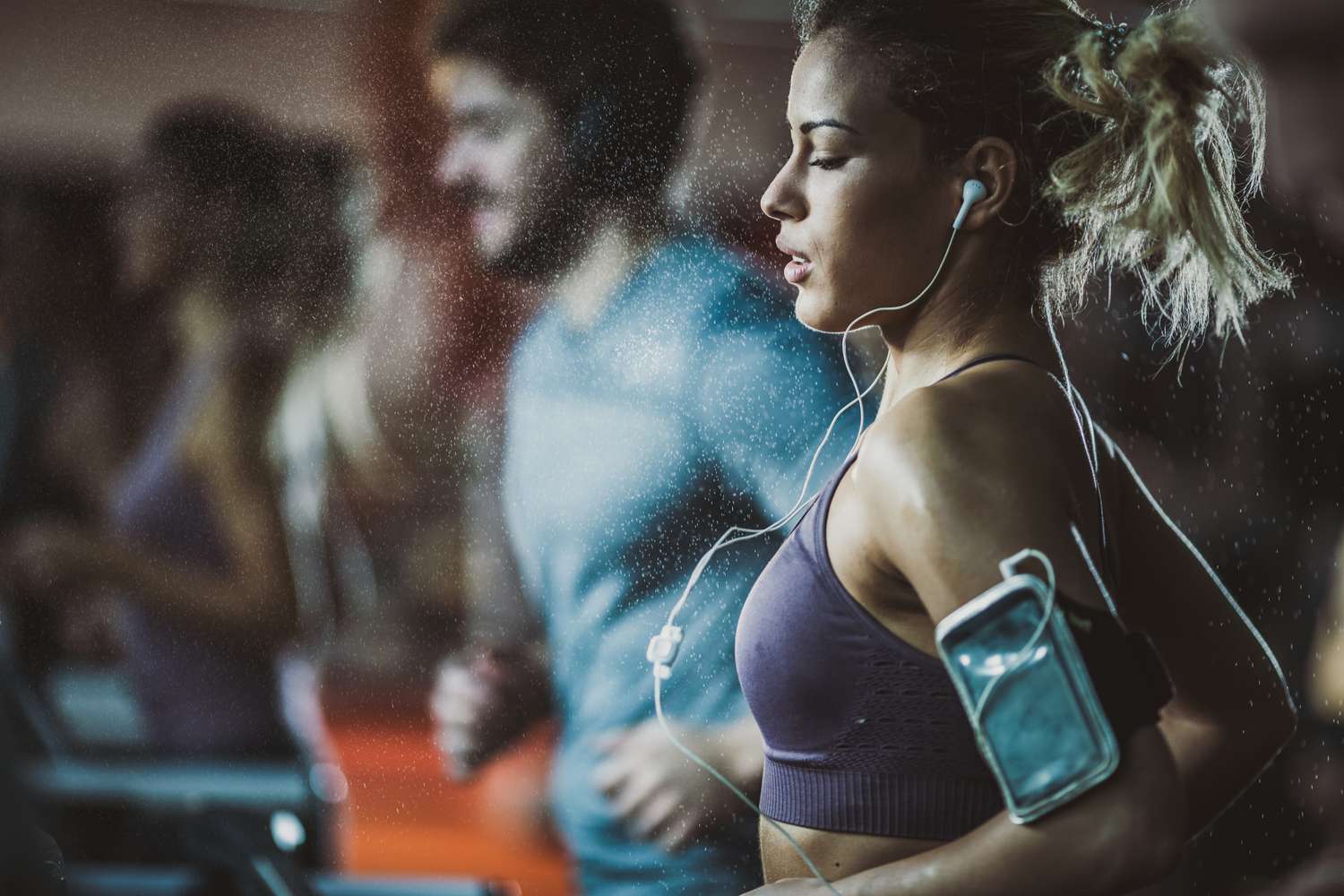 Woman with earbuds on a treadmill