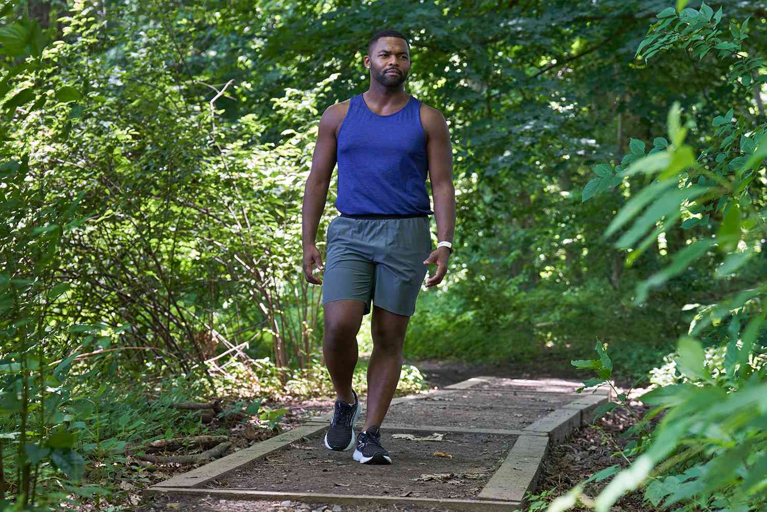 man walking on a trail in the woods