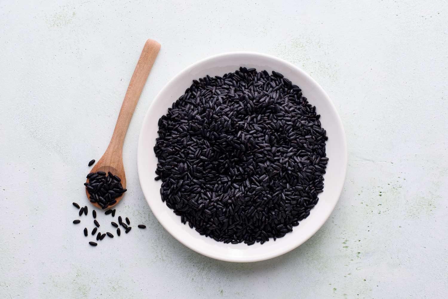 black rice in a bowl with wooden spoon