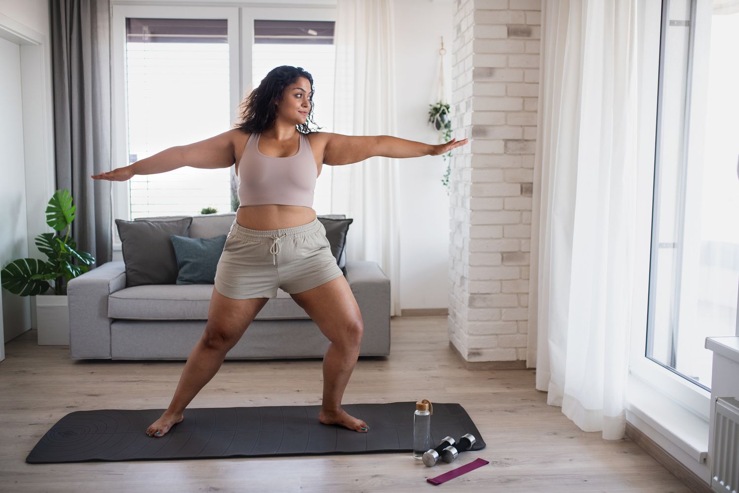woman performing yoga in living room