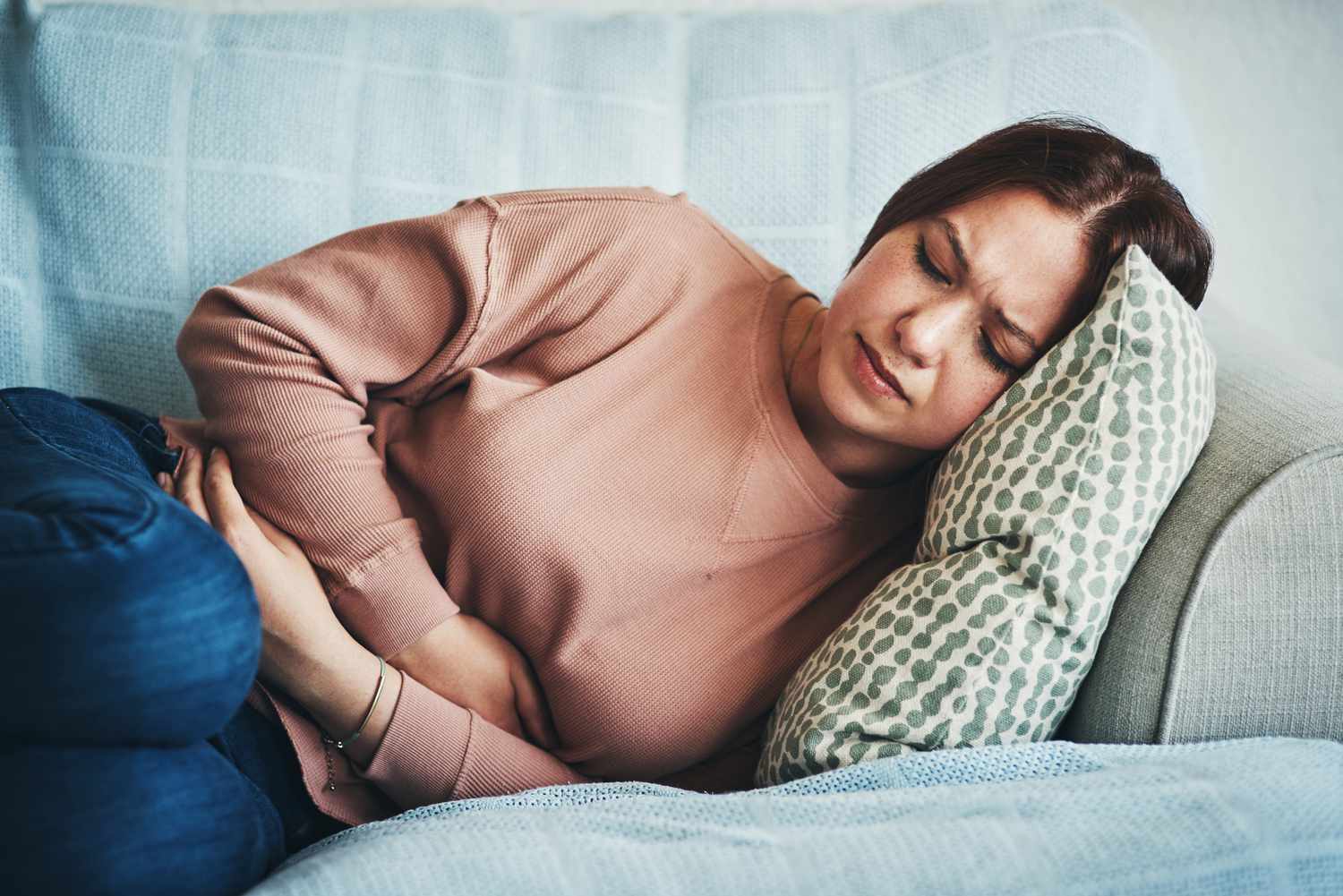 Women lying on couch not feeling well