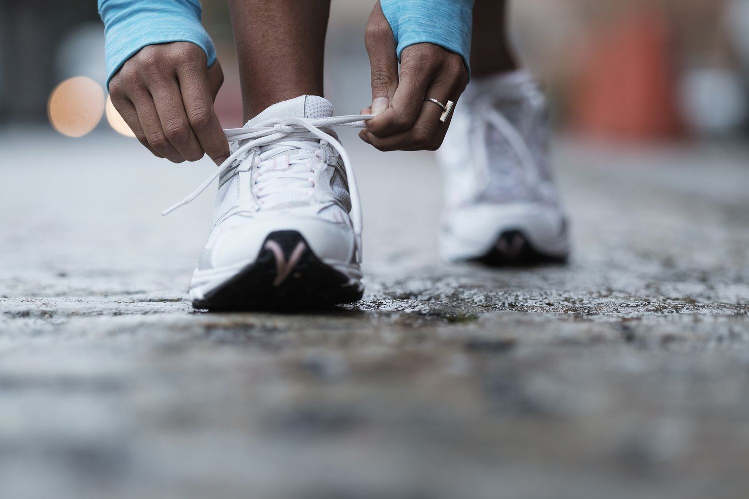 woman's hands tying shoelaces on running shoes