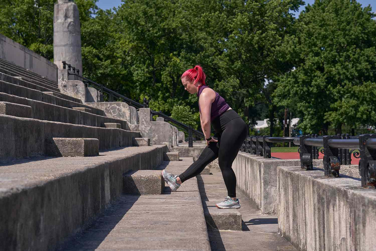 woman stretching her foot, ankle, and calf on concrete steps