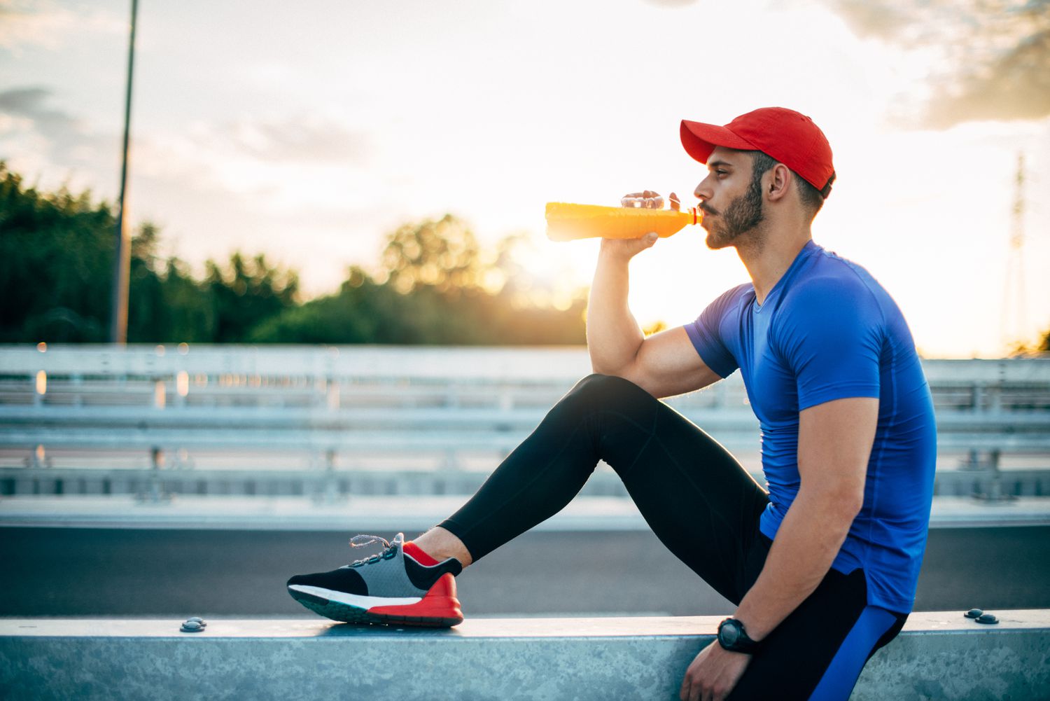Male athlete drinking hydration supplement beverage