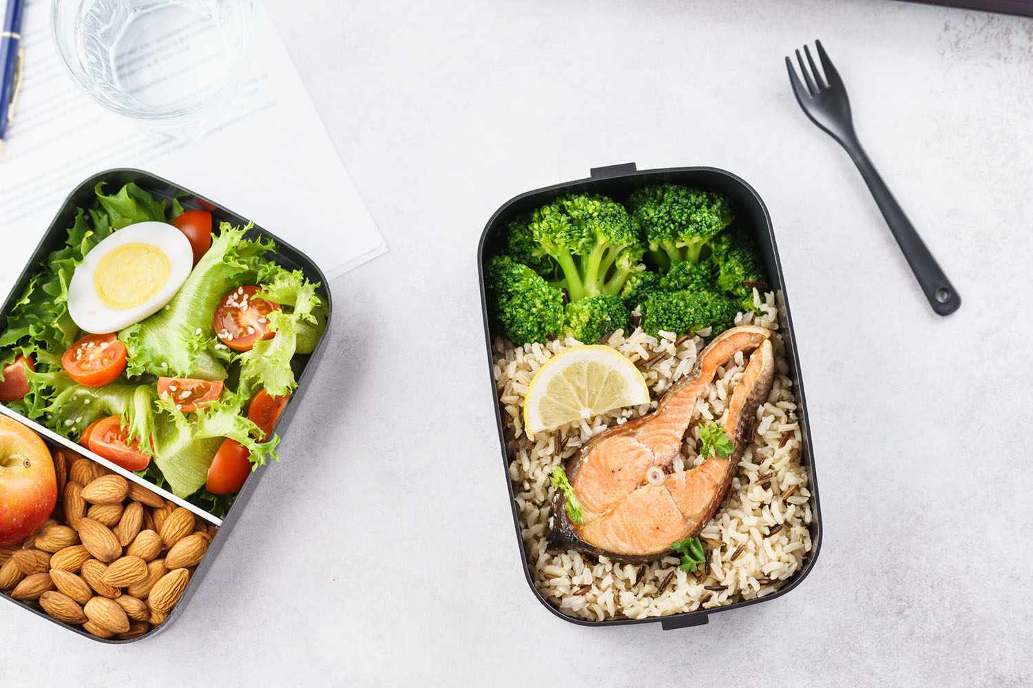 Takeaway lunch boxes with food at working desk with laptop