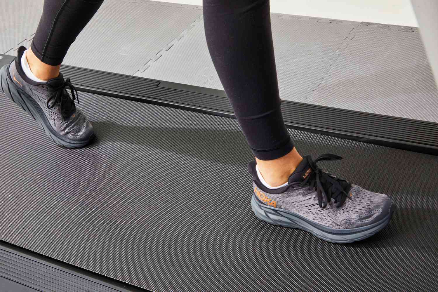Person walking on a treadmill while wearing HOKA Women's Clifton 8 Running Shoes