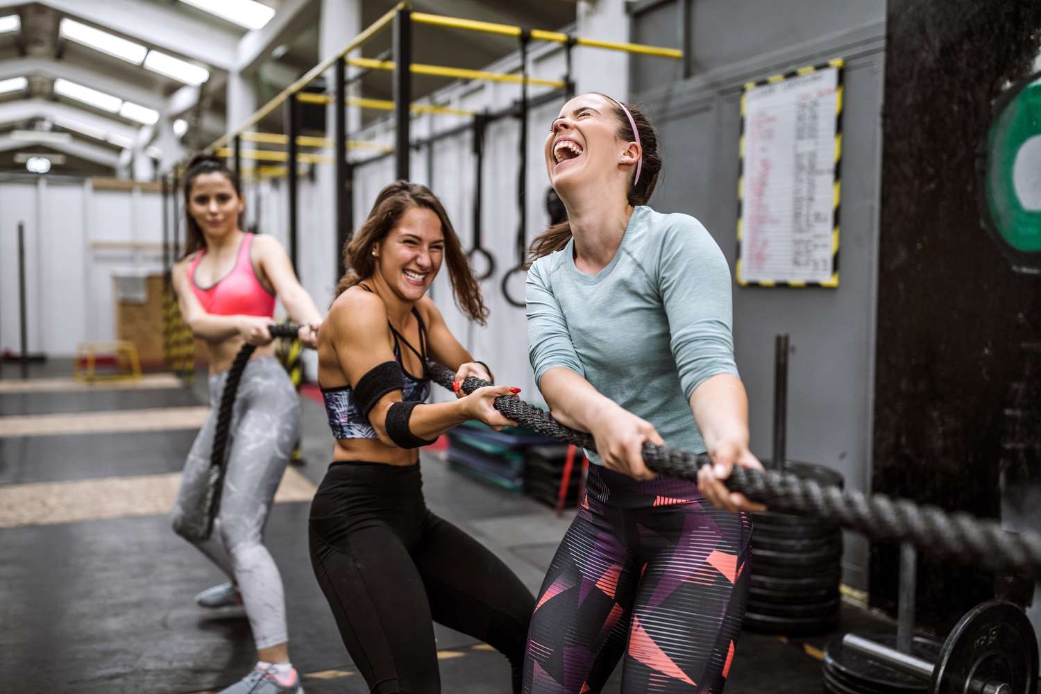 women in gym playing tug-of-war