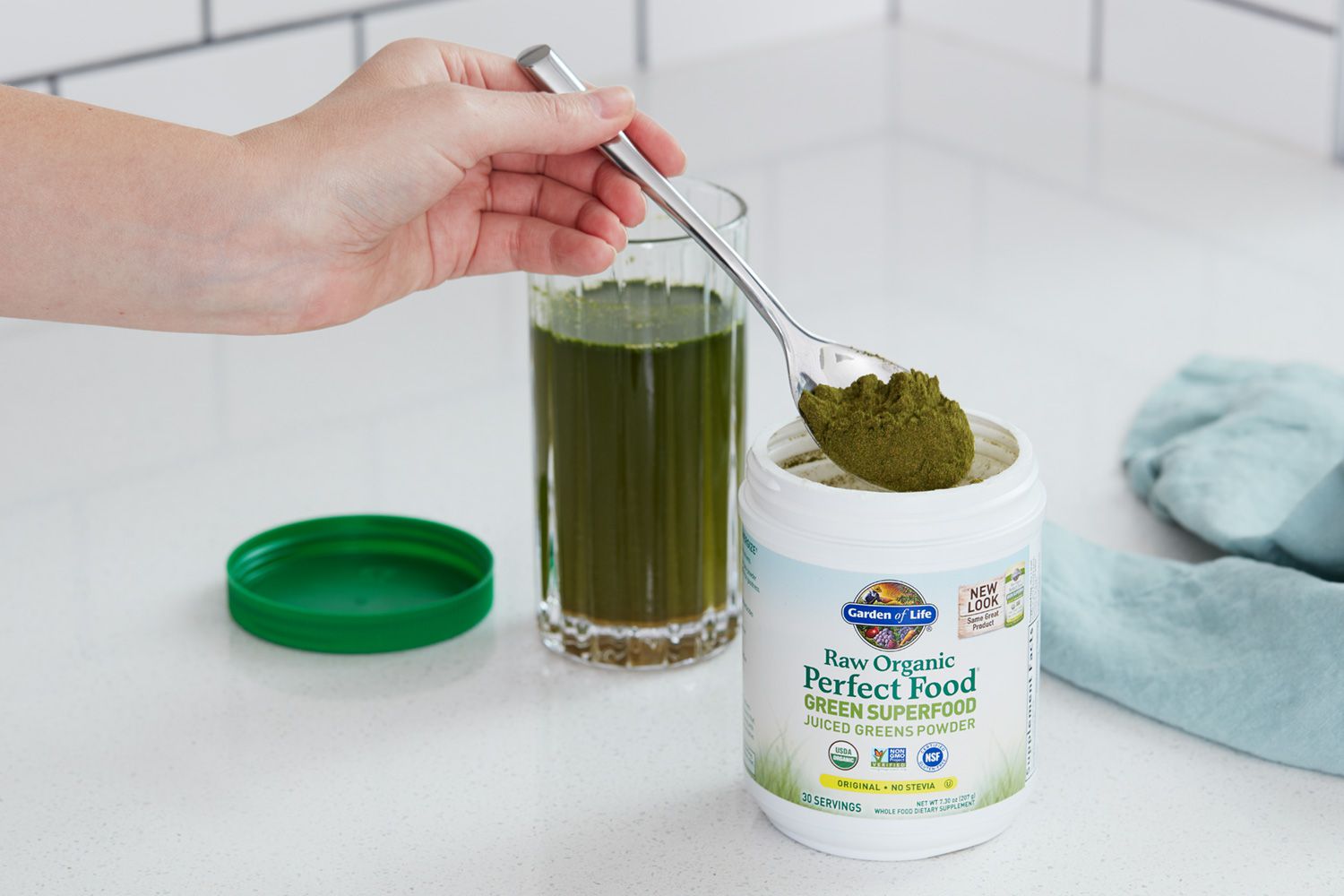 Hand holding a spoon full of Garden of Life Raw Organic Perfect Food Green Superfood powder