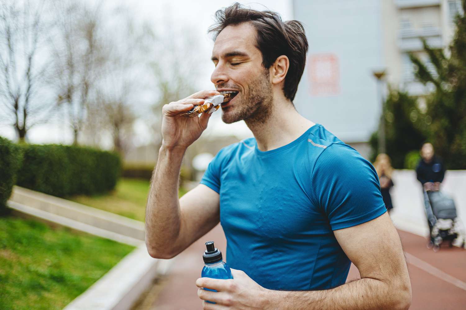 Male athlete eating protein bar