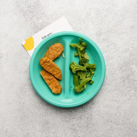 veggie tenders and broccoli on a green plate