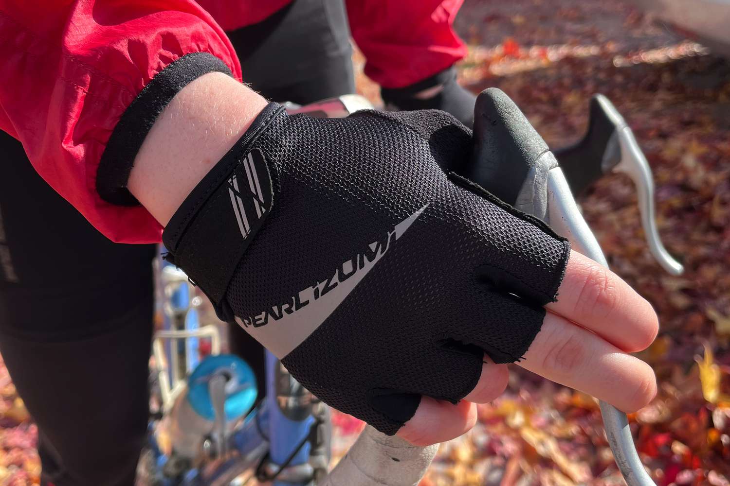 Closeup of hand wearing PEARL IZUMI Women’s Select Glove while squeezing bike brake