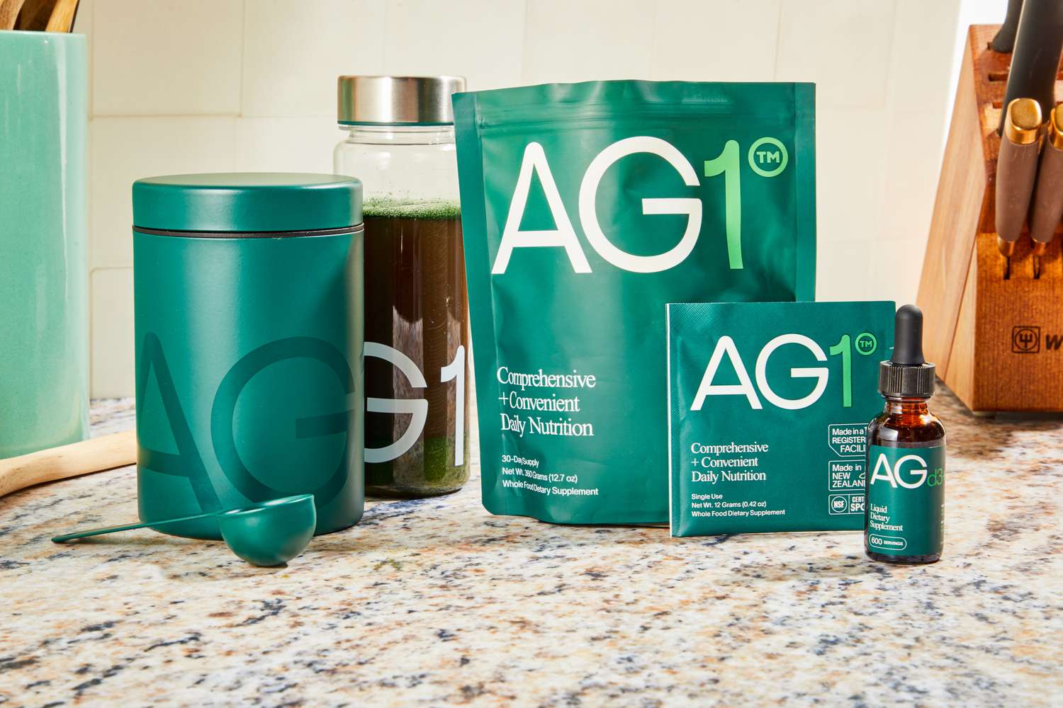 Containers of AG1 by Athletic Greens displayed on a kitchen counter