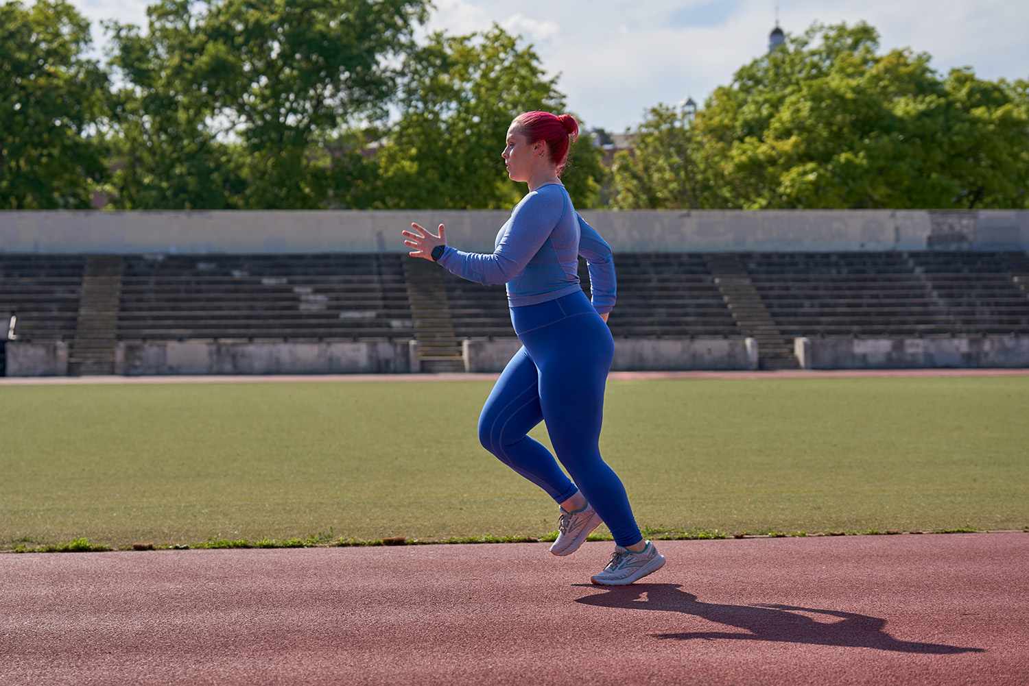 woman in all blue running on a track