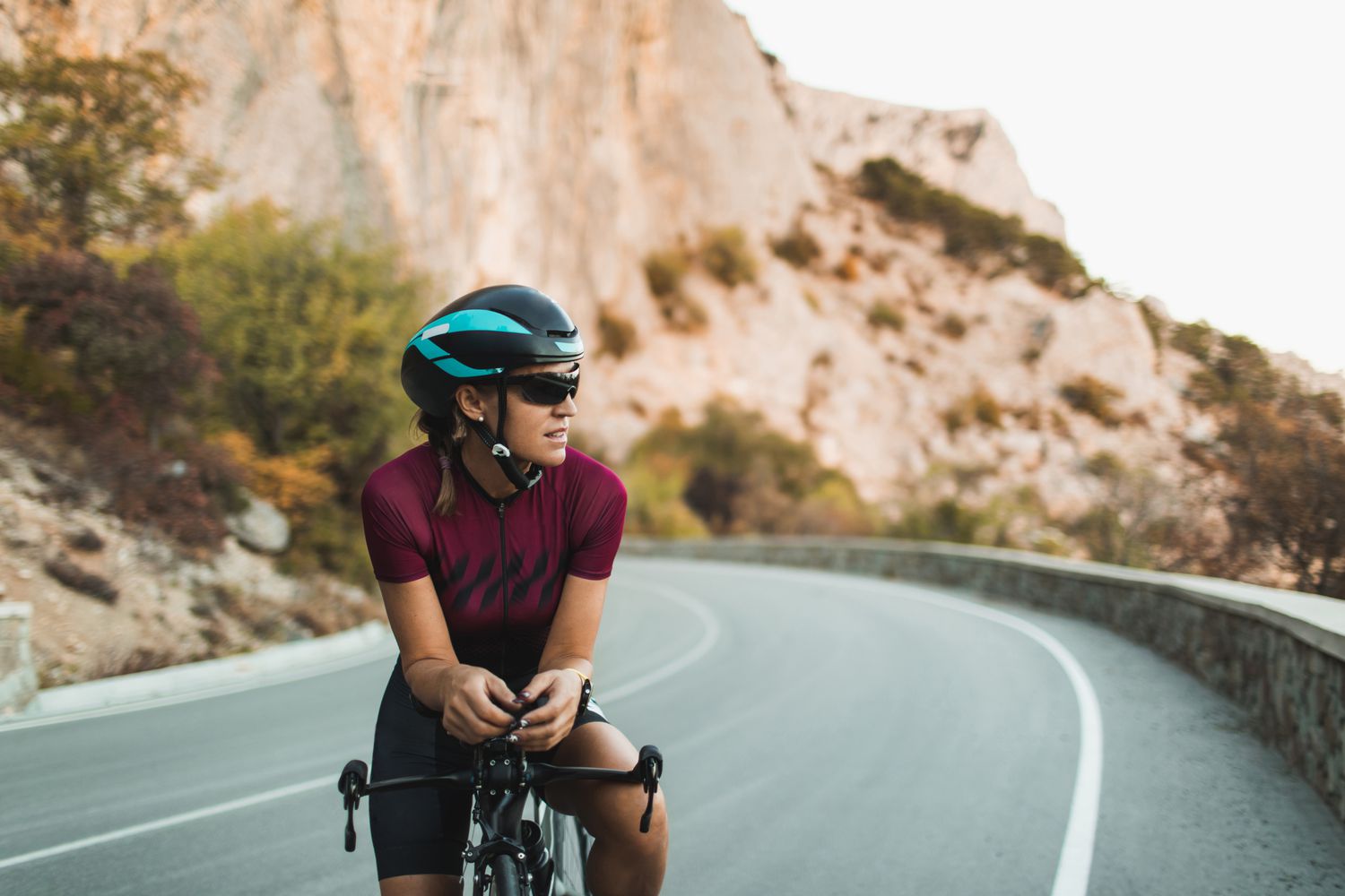 Portrait of Cyclist Woman on Road Bike with Sunglasses and Helmet
