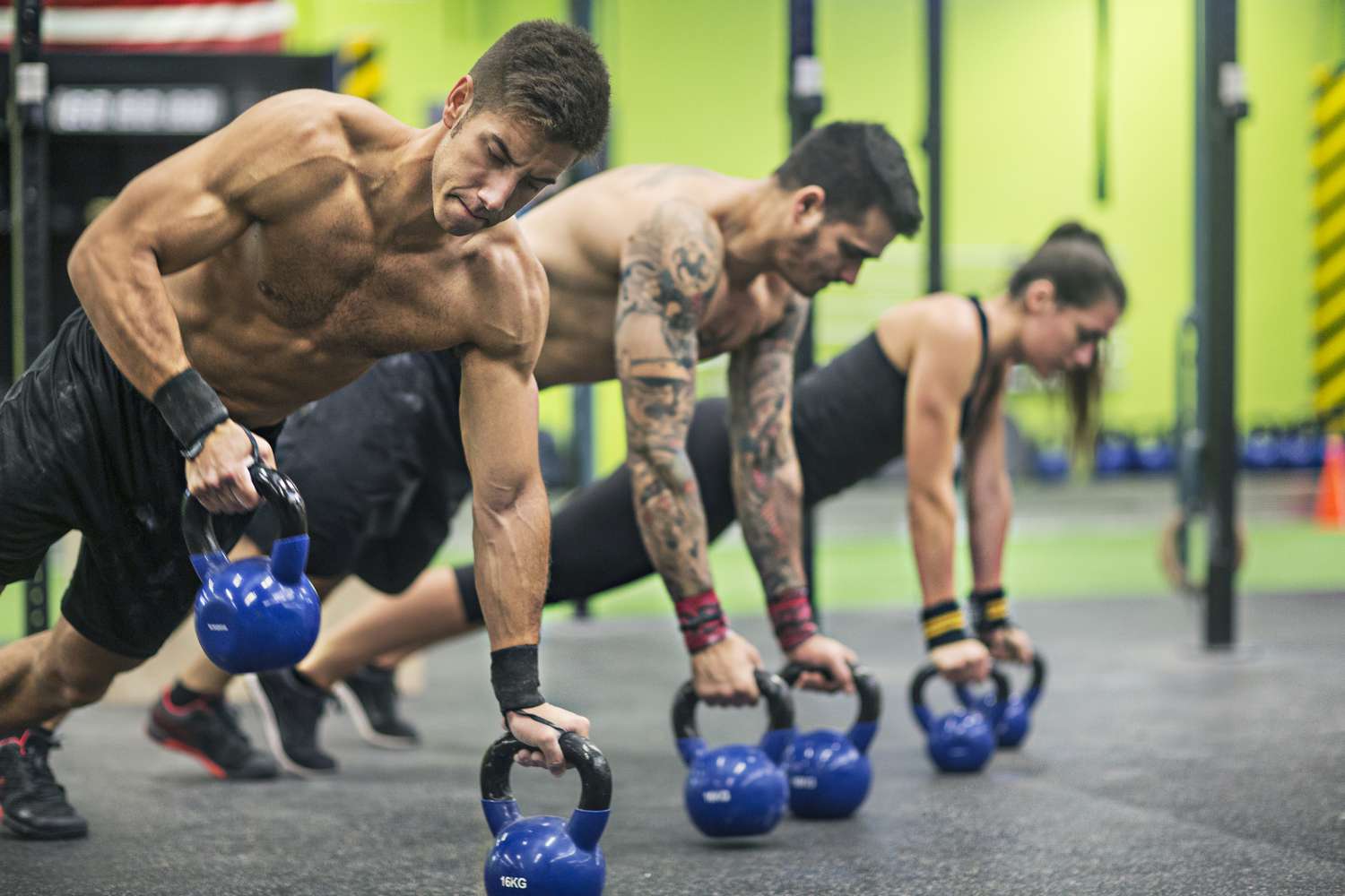 two men and a woman doing rows with kettlebells