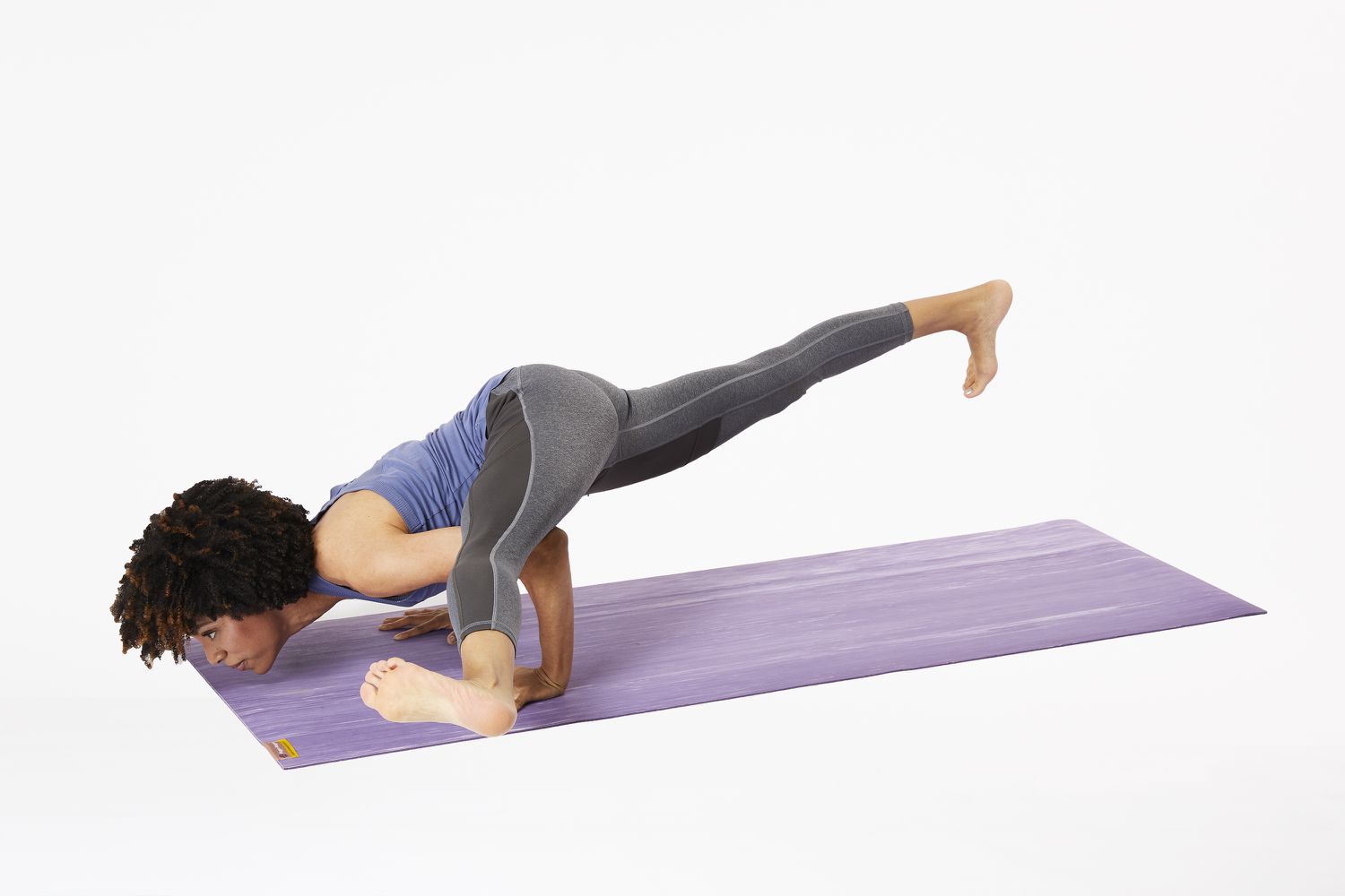 Woman on yoga mat in hurdler pose