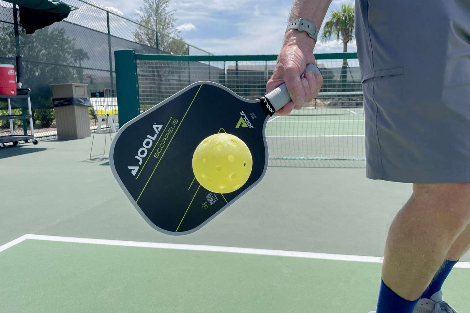 A person using the JOOLA Anna Bright Scorpeus CFS 14 Pickleball Paddle to hit a ball