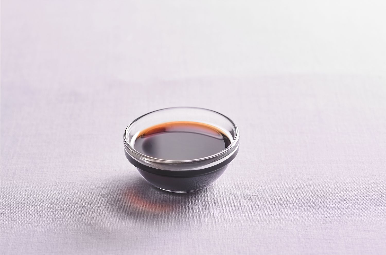 Small condiment dish filled with liquid soy sauce