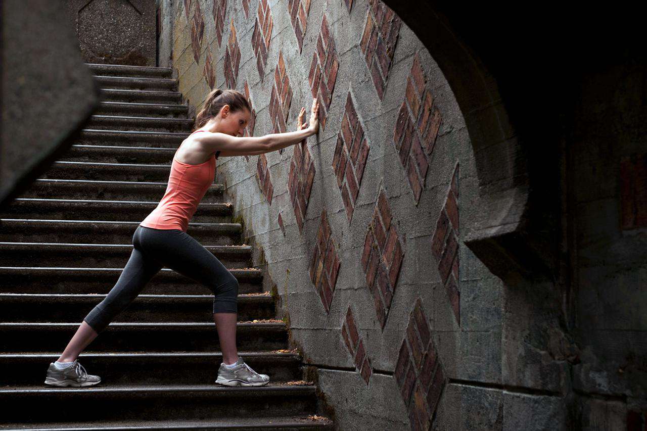 Woman stretching on city steps