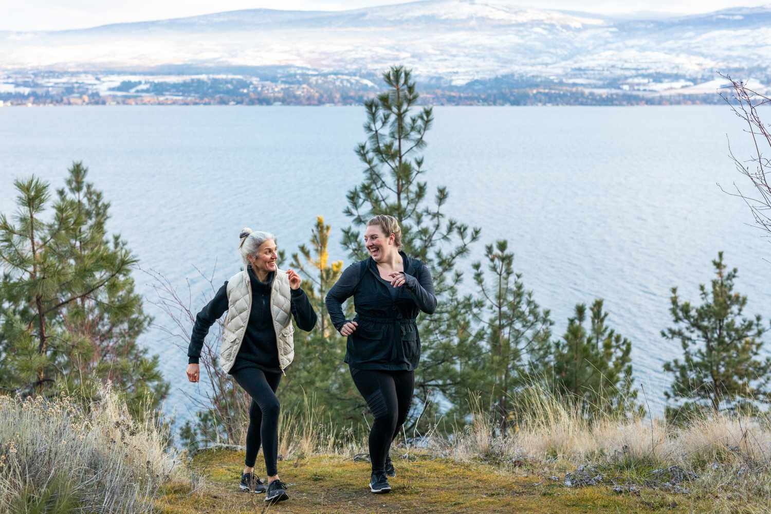 two women walking together on a coastal mountain trail