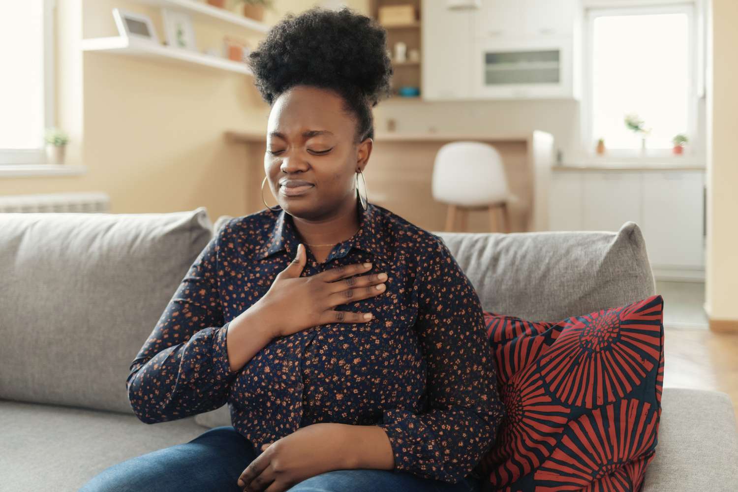 woman holding chest with heartburn