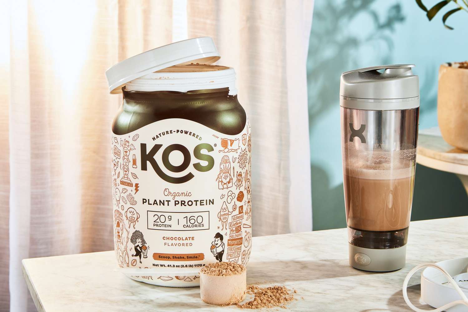 KOS Vegan Superfood Protein Powder bottle next to a scoop and shaker