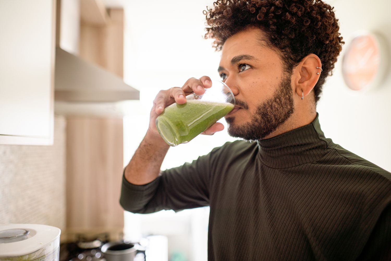 Man drinking a green smoothie