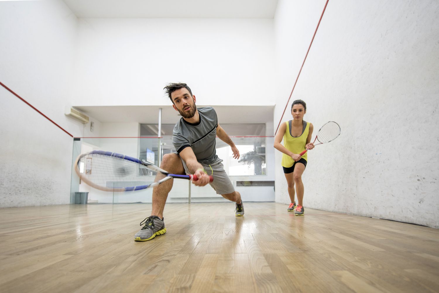 Below view of young man and woman playing squash