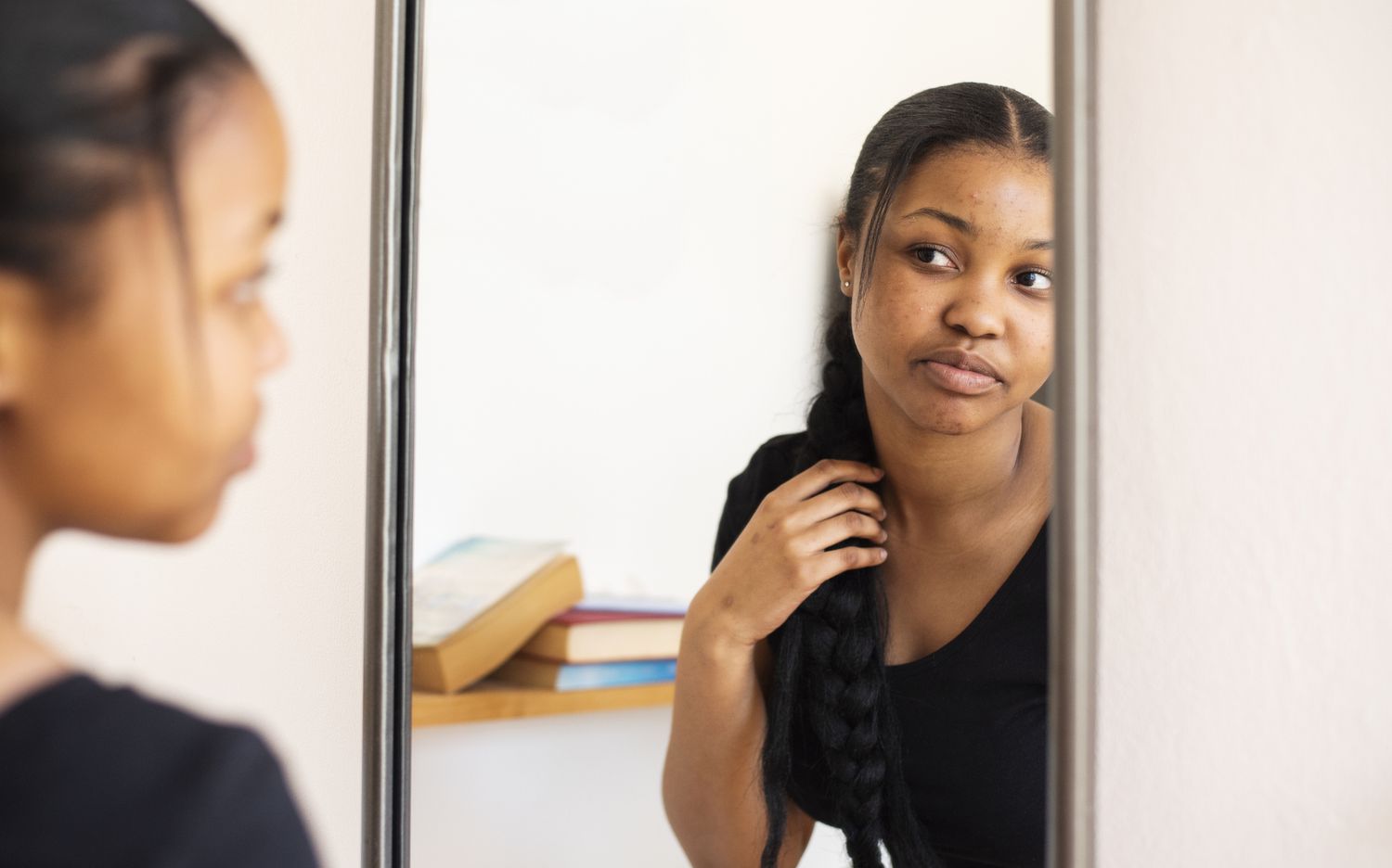 Teen girl looking in the mirror
