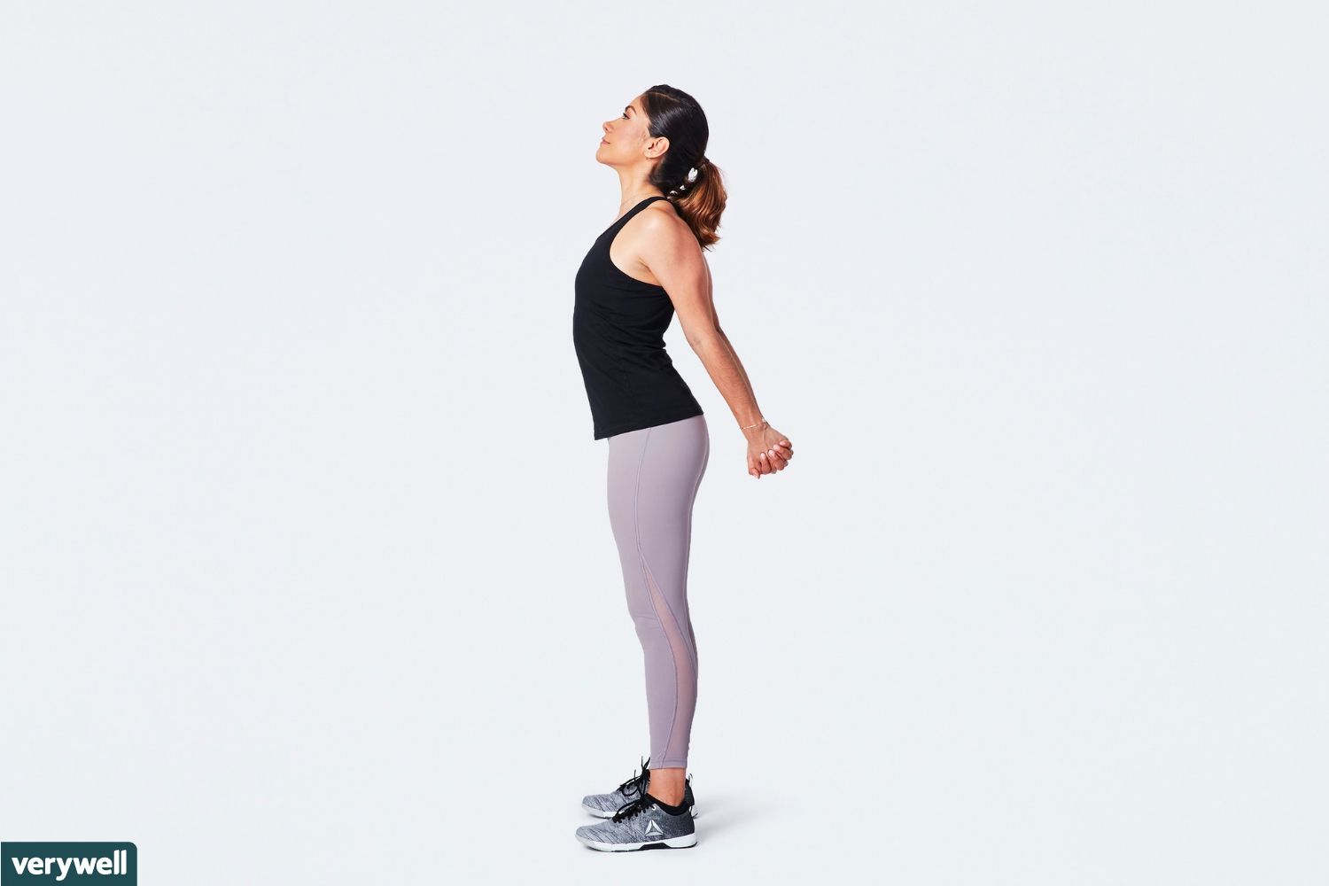 woman doing standing chest opener stretch