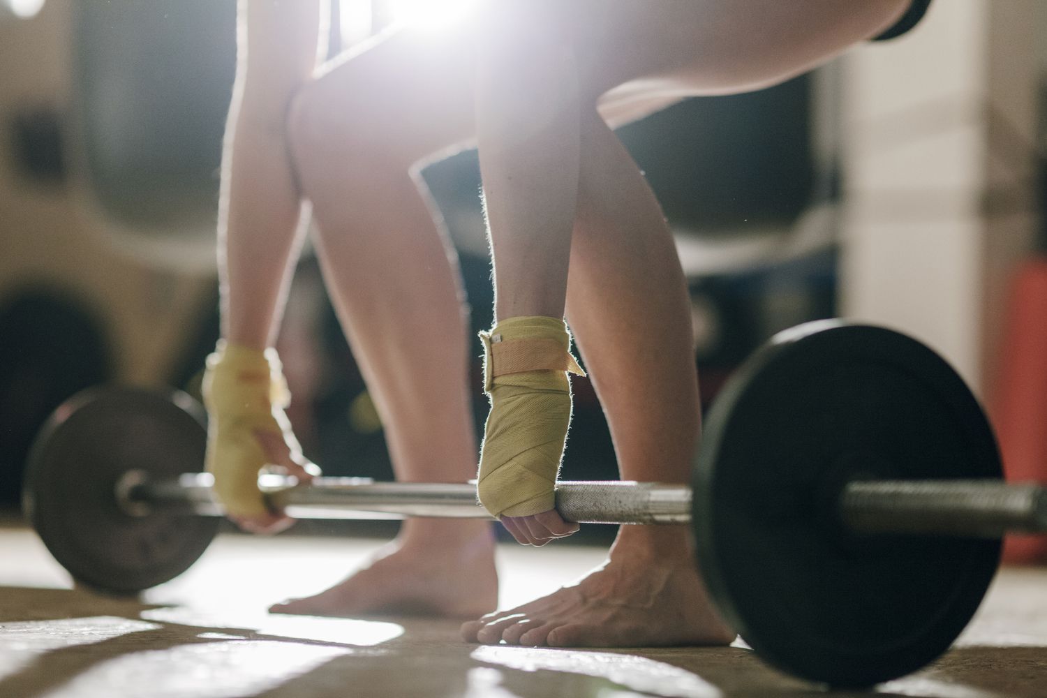 Person lifting weights barefoot
