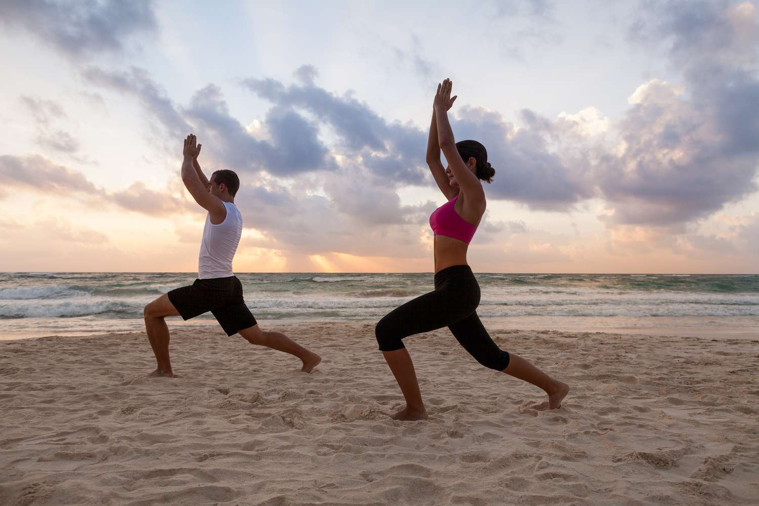 Couple Practicing Yoga on the Beach