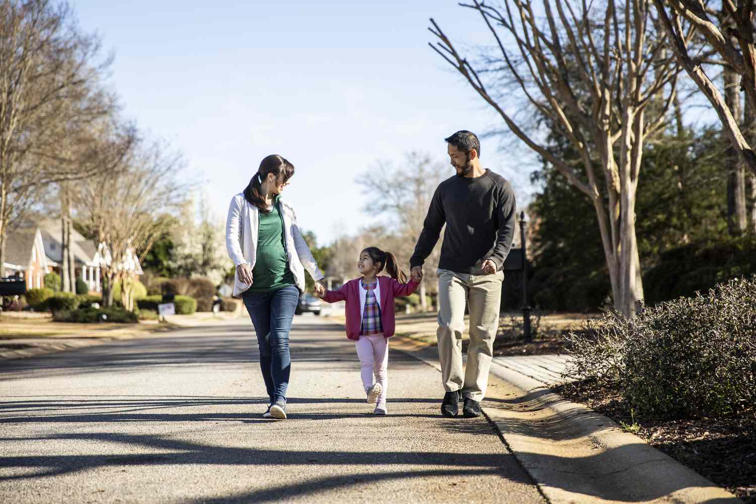 Family of three walking in a neighborhood