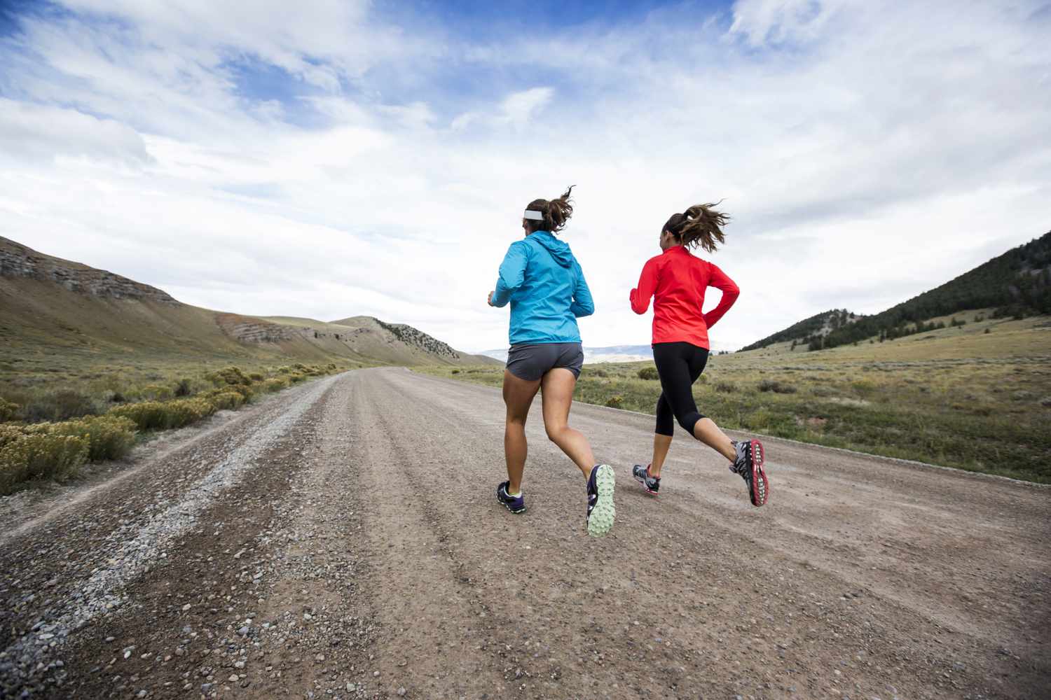 Two women running on dirt road