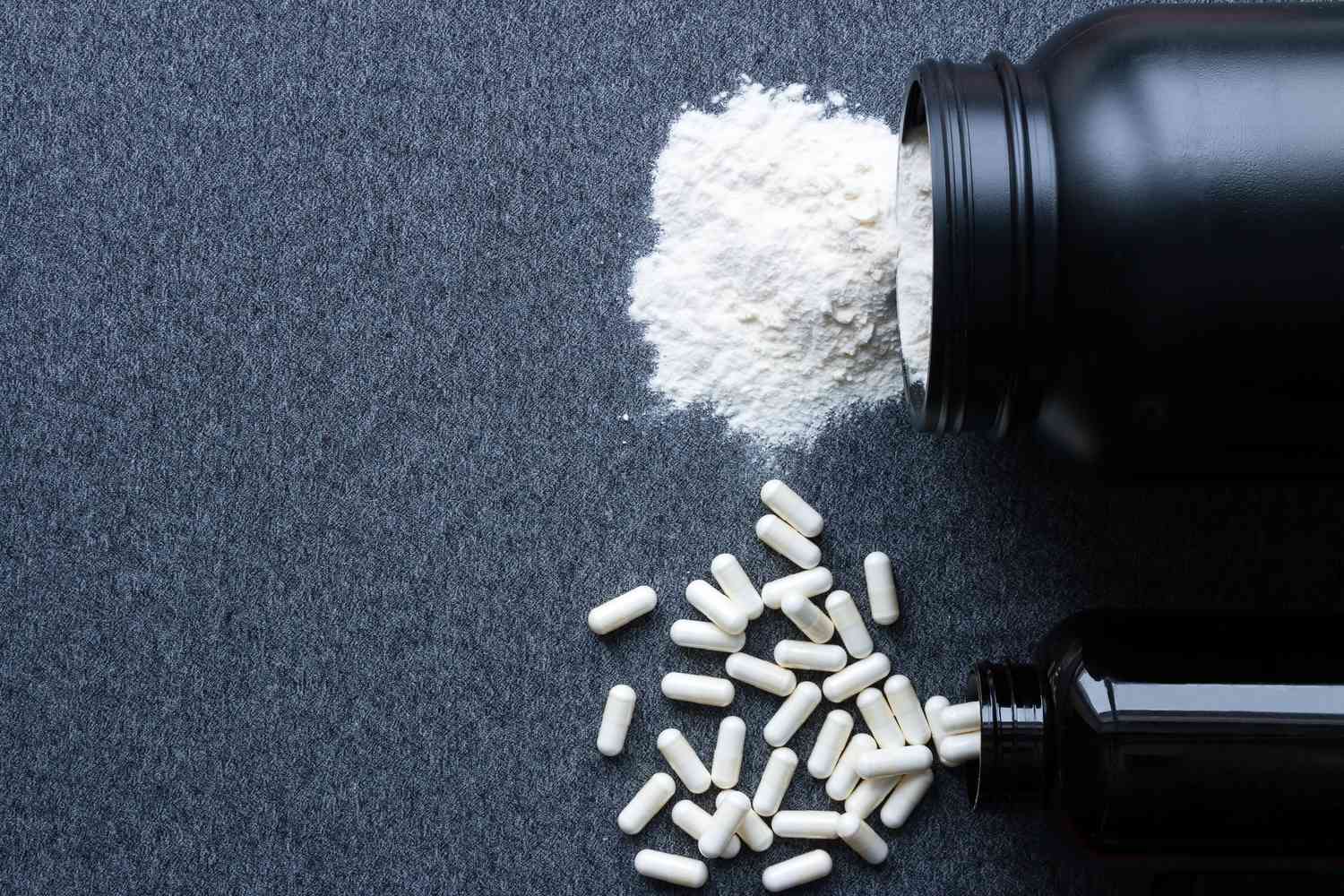 Supplement powder and pills coming out of bottles