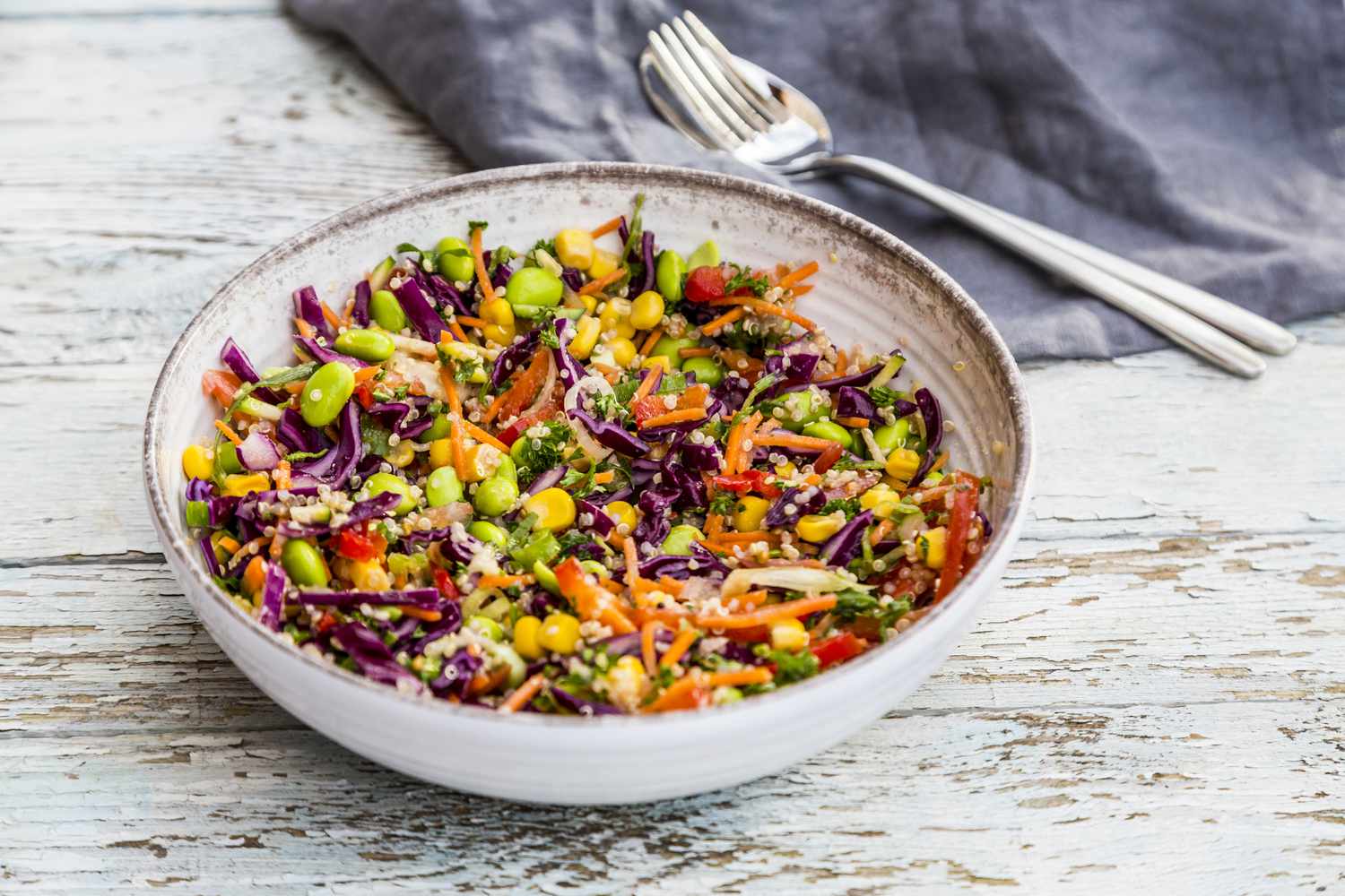 a colorful quinoa salad in a white bowl